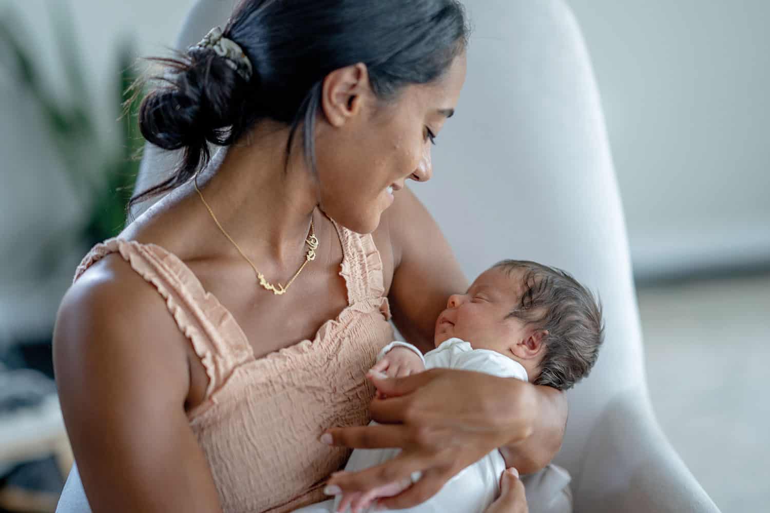 photo of young mum looking down at her baby in her arms